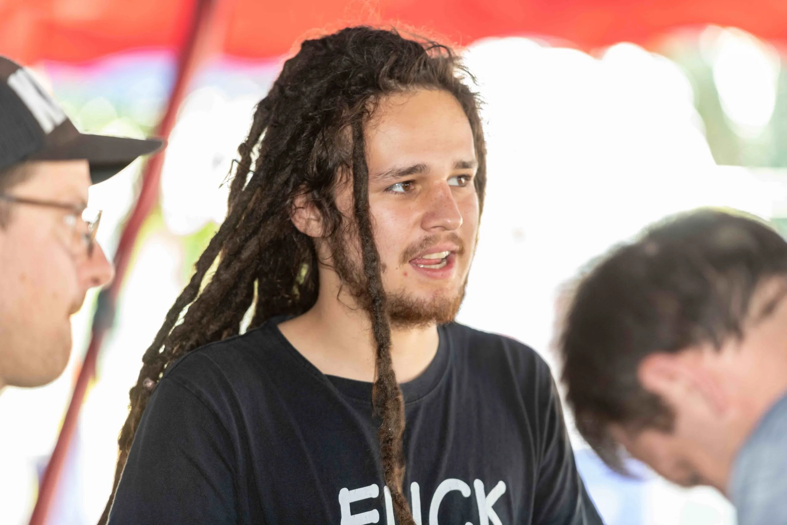 Junger Mann mit Dreadlocks und schwarzem T-Shirt