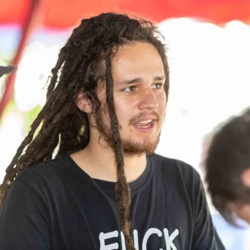 Junger Mann mit Dreadlocks und schwarzem T-Shirt