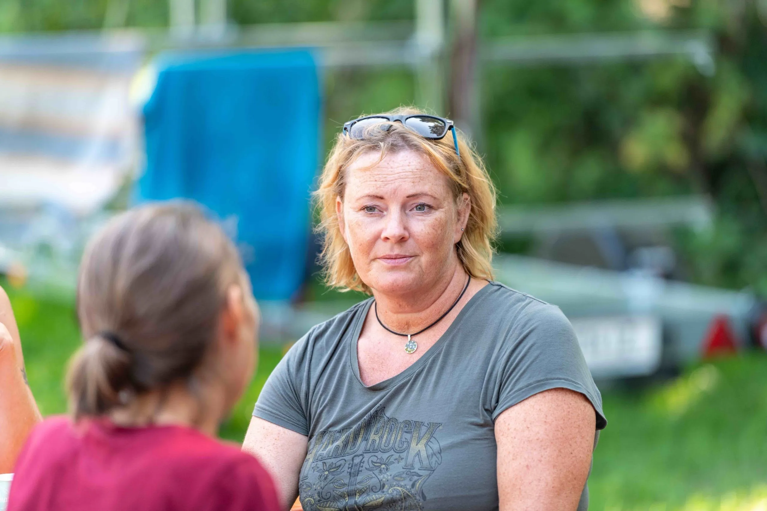Frau mit Sonnenbrille und grauem T-Shirt