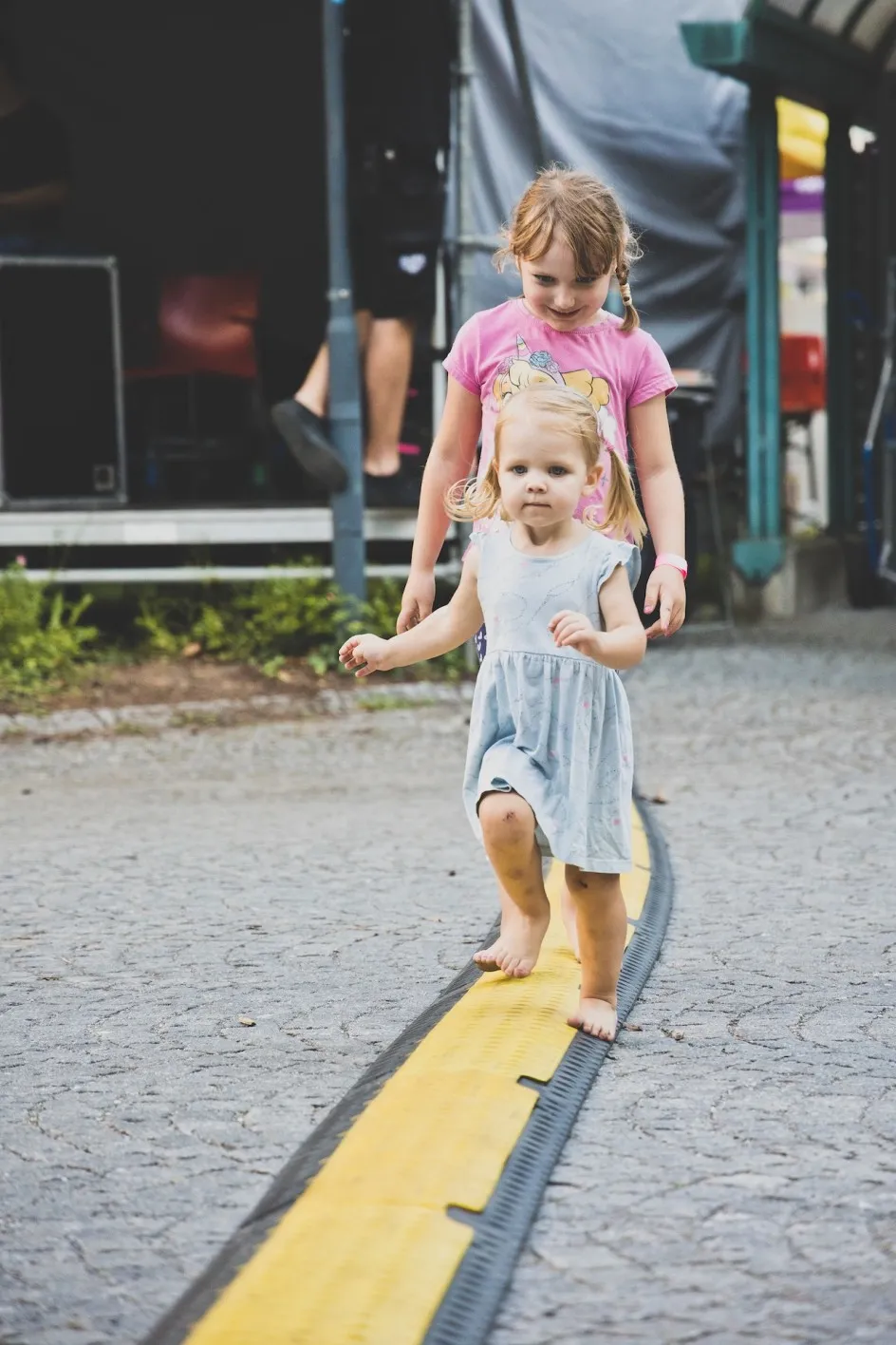 Zwei Mädchen balancieren über eine Abdeckung