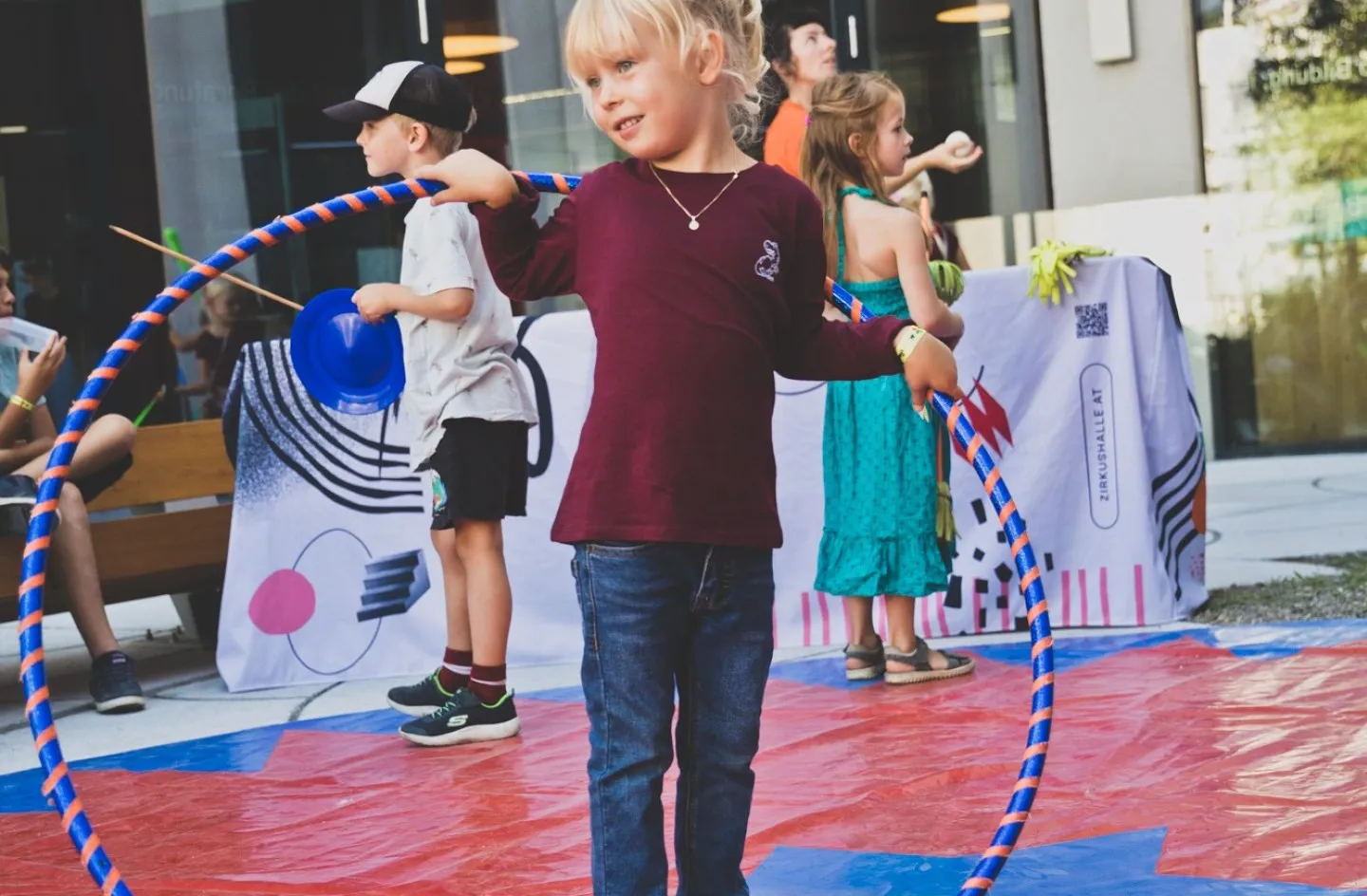 Zirkusworkshop mit der Zirkushalle Dornbirn Kinder am üben mit Hula Hoop Reifen